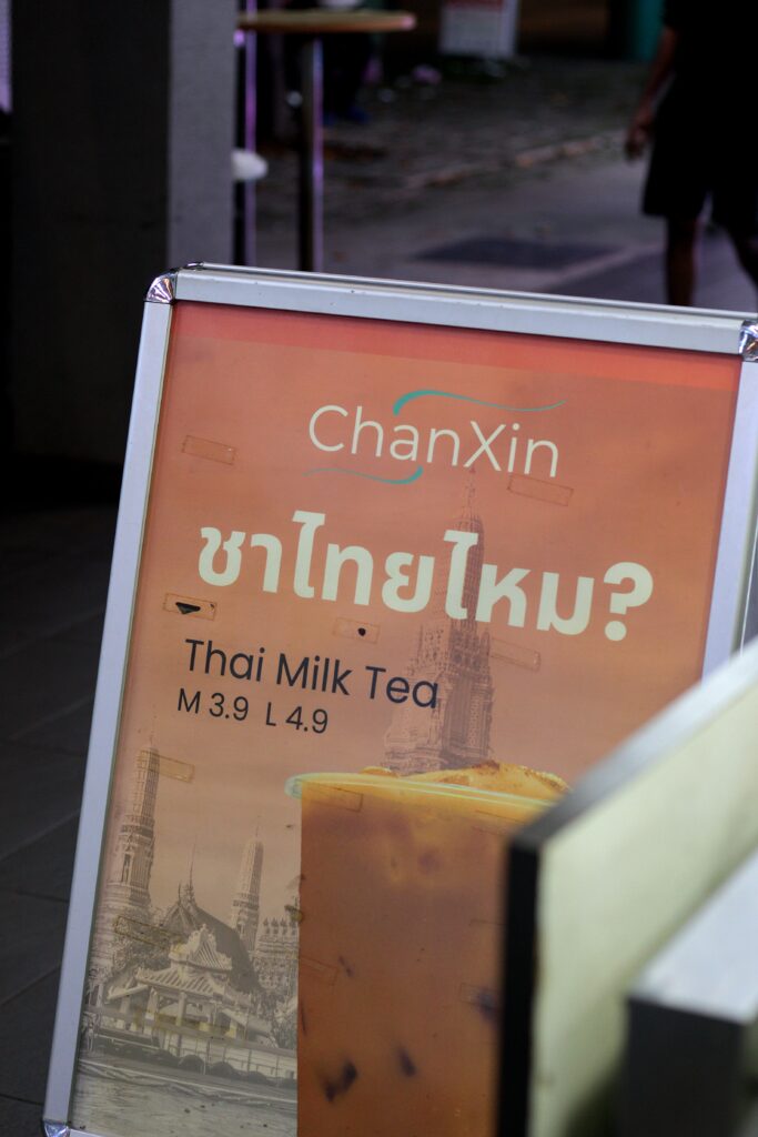 An image showing an A-frame signage selling Thai Milk Tea