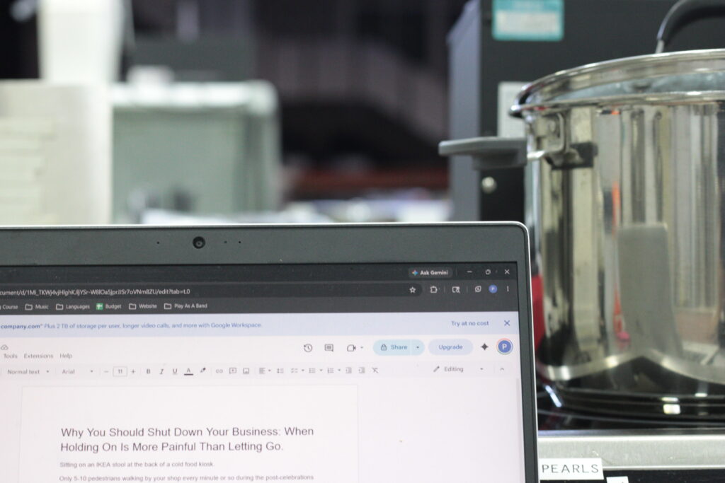 An image showing laptop with a Google Doc of the current post being written while writer is in the kitchen
