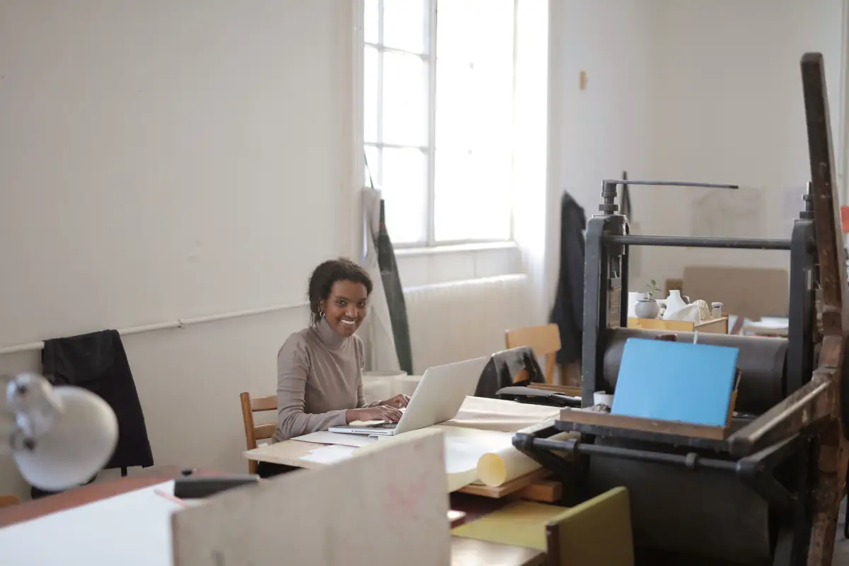 An image of a smiling entrepreneur working in her office