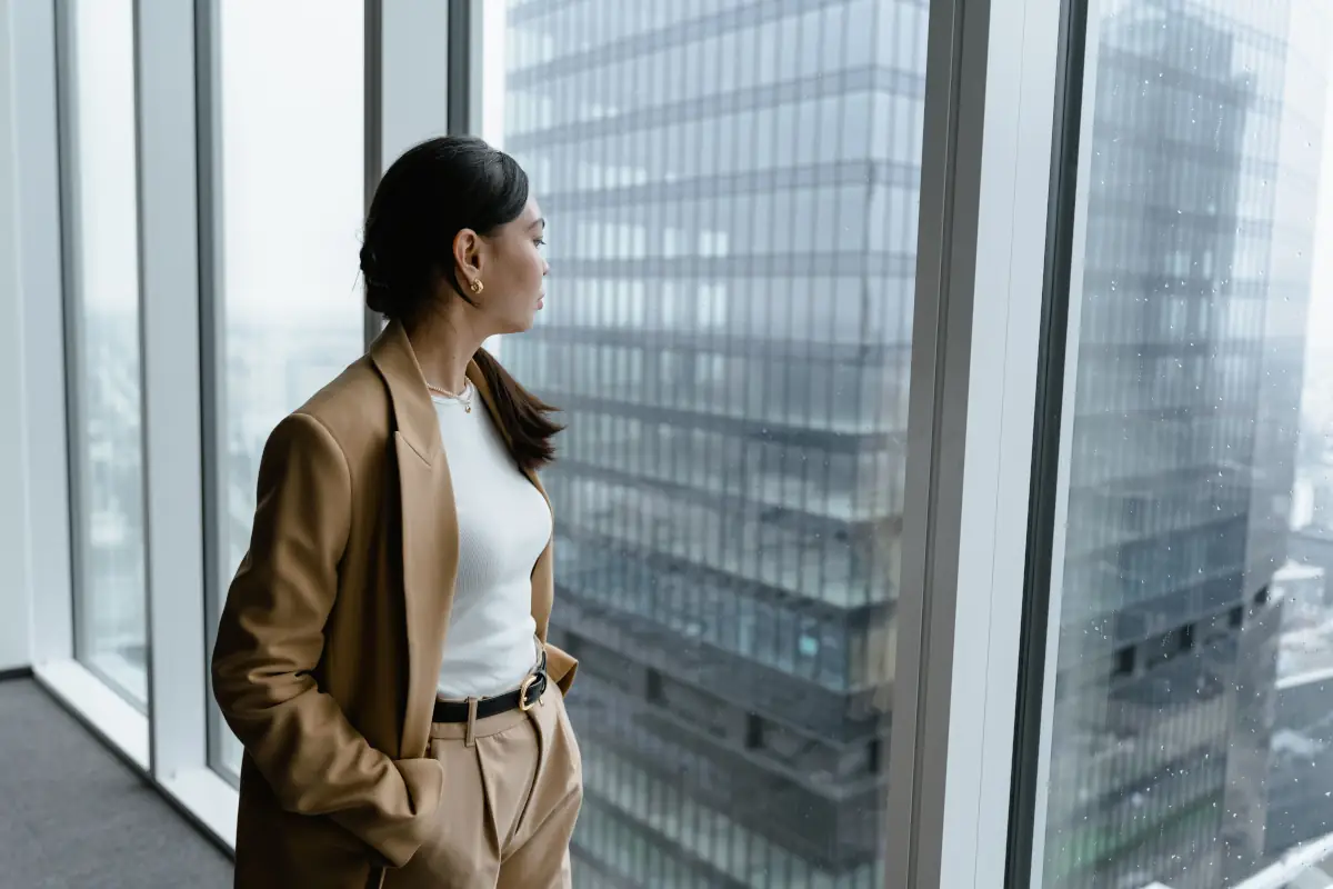 An image of an office lade staring out the window
