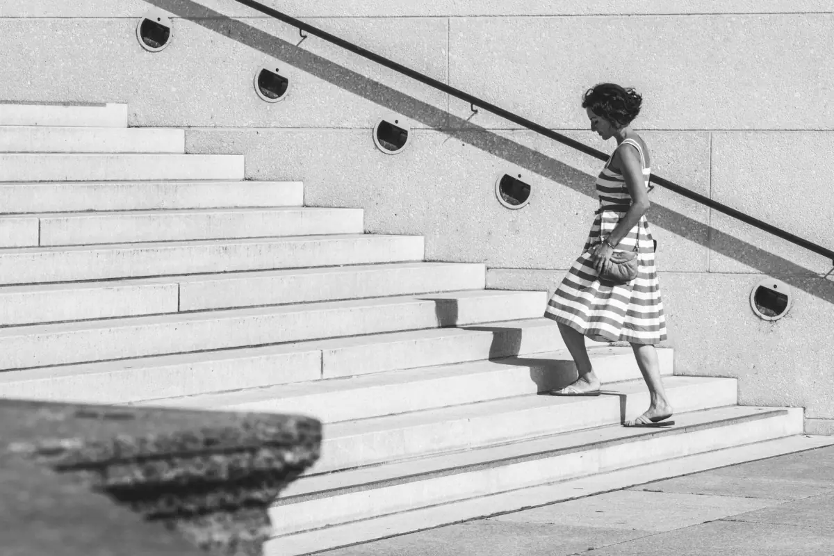 An image of a woman taking the first few steps of a staircase